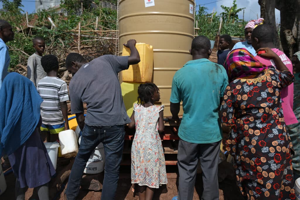 Les habitants du bidonville viennent remplir leurs bidons avec l’eau potable ramenée par la Croix Rouge. Les premiers sont arrivés tôt le matin plusieurs heures avant l’arrivée du camion.