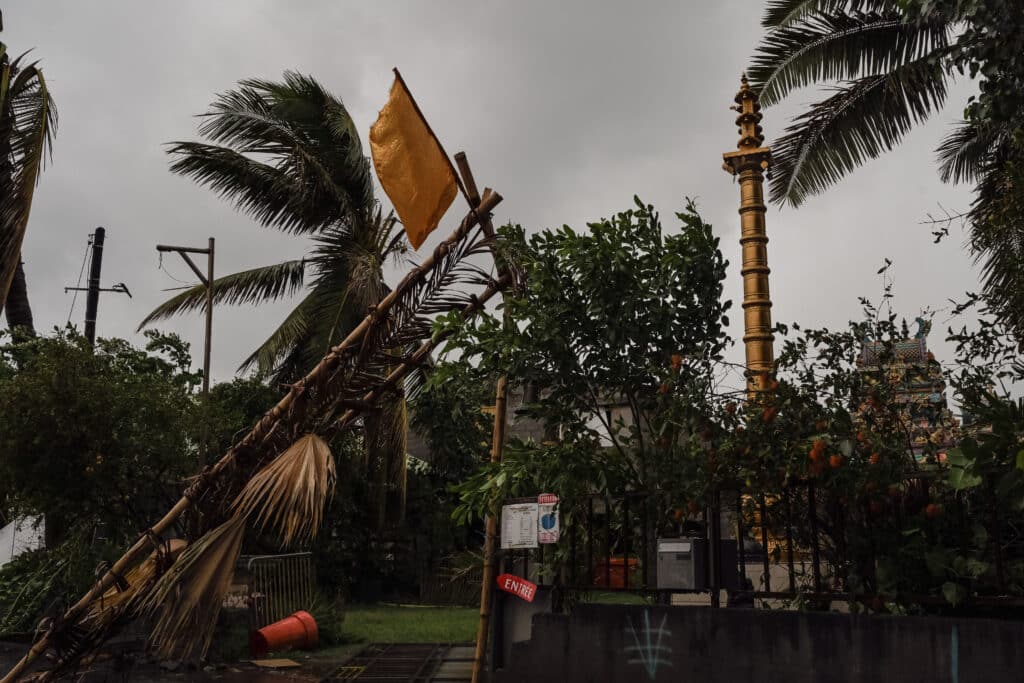 Devant un temple; on distingue les dégâts causés par le passage du cyclone. Le portail git au sol alors qu'un poteau s'est complètement effondré.