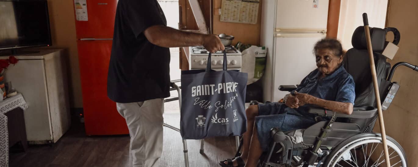 Abdou remet un panier alimentaire à madame Itema, bénéficaire de l'aide du CLAP.