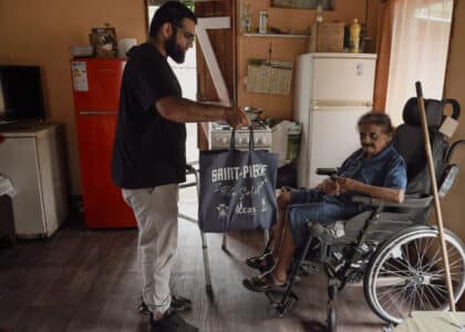 Abdou remet un panier alimentaire à madame Itema, bénéficaire de l'aide du CLAP.