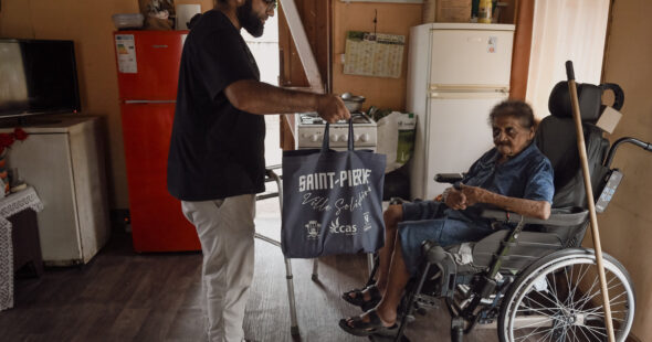 Abdou remet un panier alimentaire à madame Itema, bénéficaire de l'aide du CLAP.