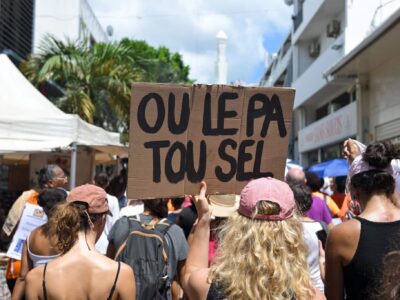 Une manifestante tient une pancarte sur laquelle on peut lire 