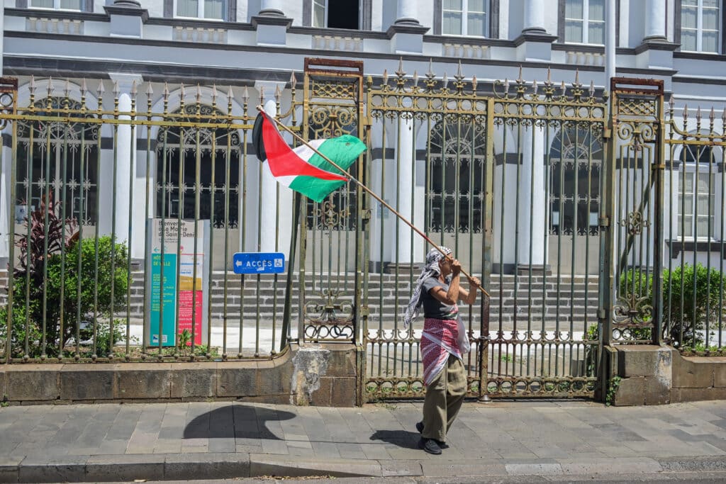 Une militante du collectif Réunion-Palestine brandit un drapeau palestinien devant l'hotel de ville de Saint-Denis.